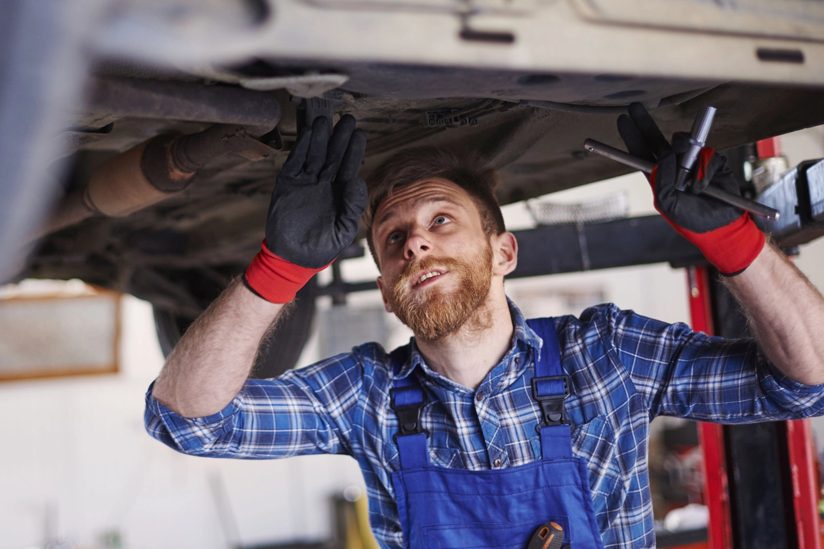 Ein Kfz-Mechaniker prüft den Unterboden eines Autos