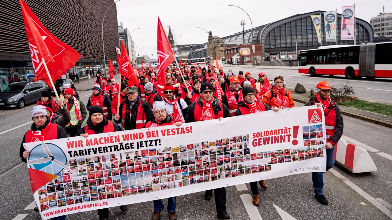 Menschenmasse mit Transparent läuft über die Straße