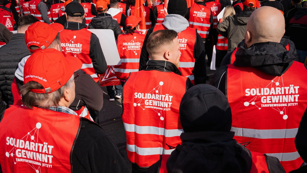 Beschäftigte tragen rote Westen mit dem Aufdruck „Solidarität gewinnt. Tarifbewegung jetzt“ auf dem Rücken