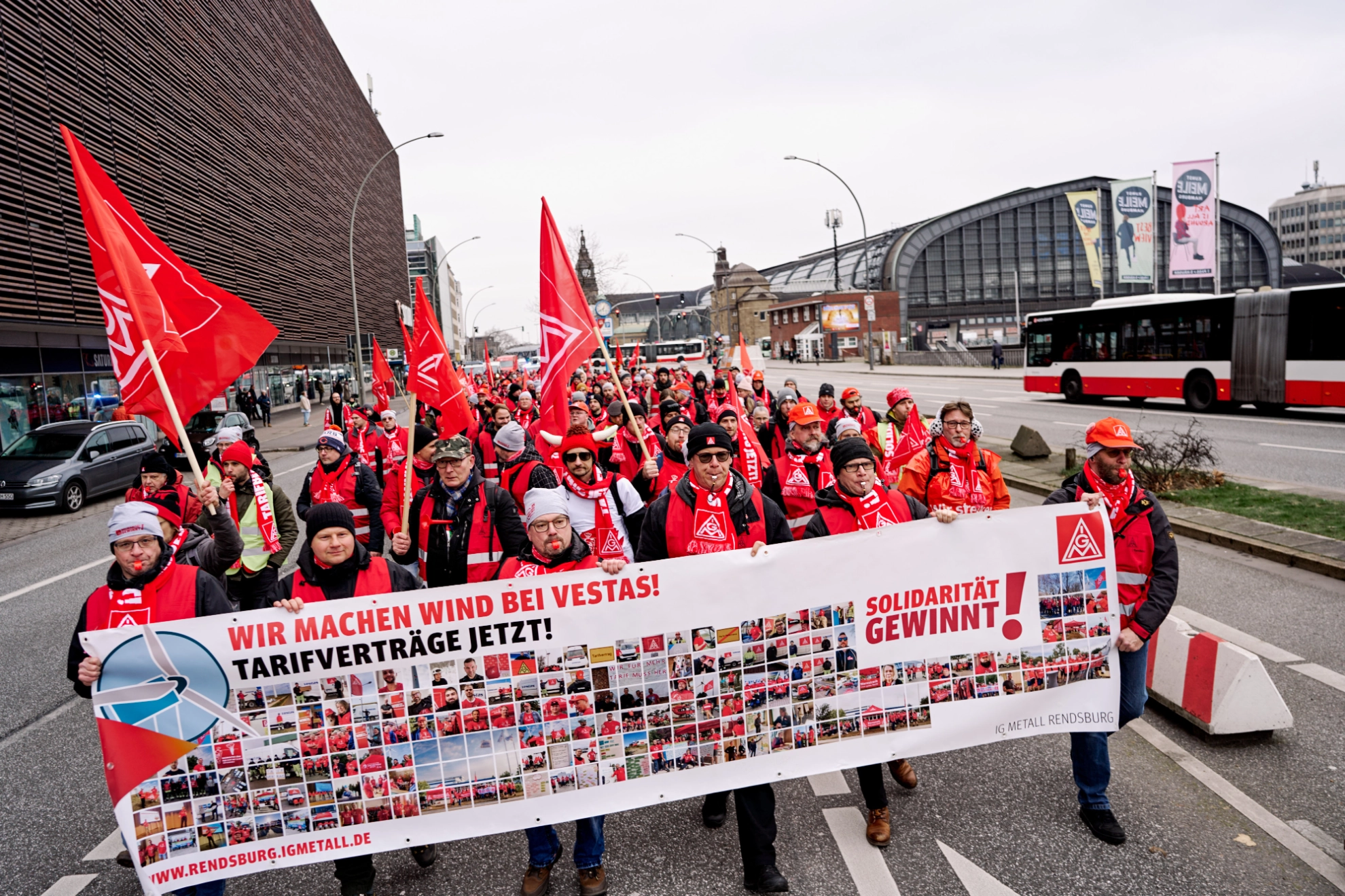 Menschenmasse mit Transparent läuft über die Straße