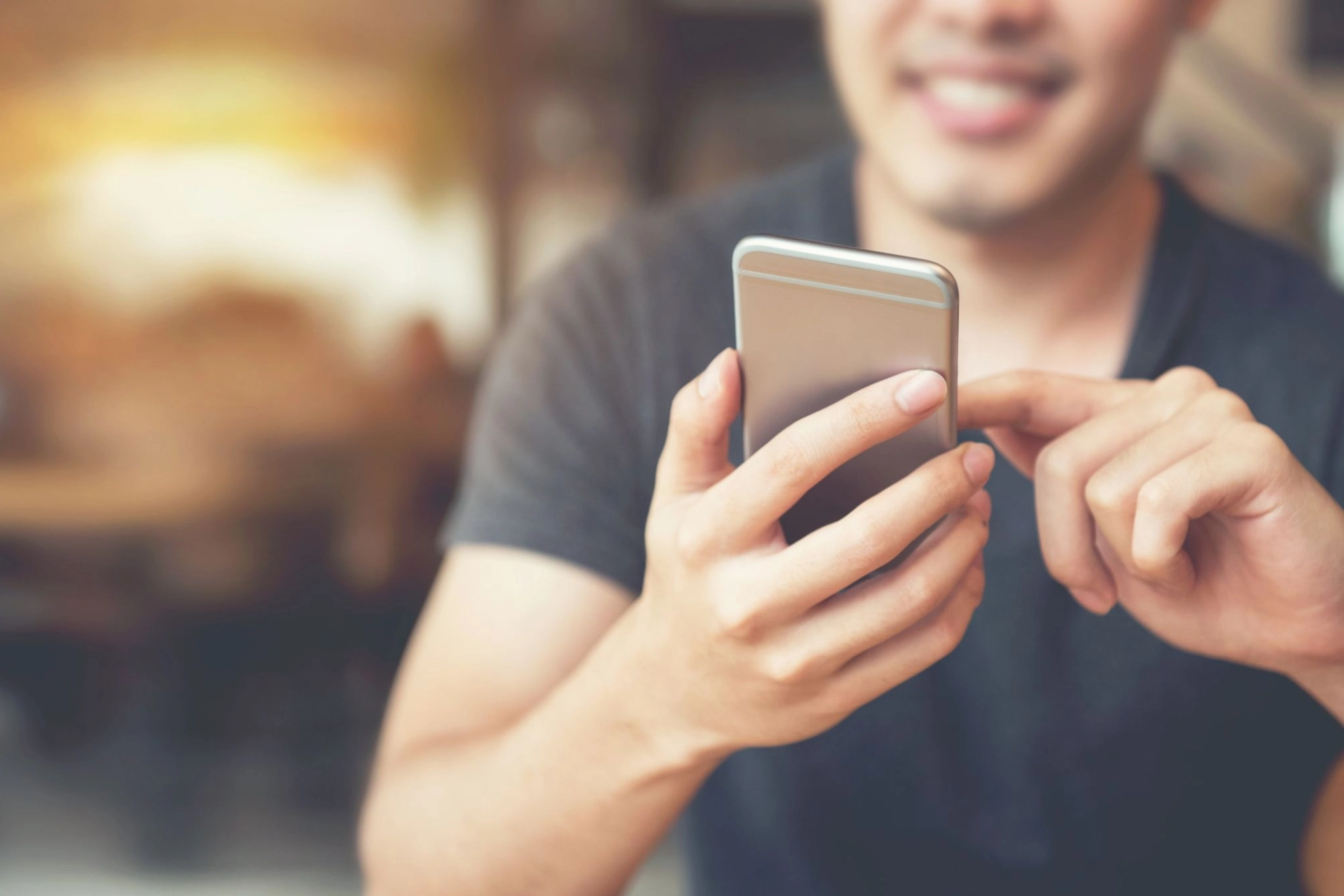 junger Mann bedient ein Smartphone