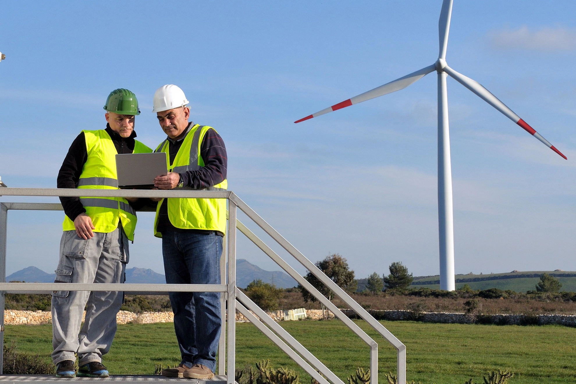 Zwei Wartungstechniker prüfen die Funktion einer Windkraftanlage