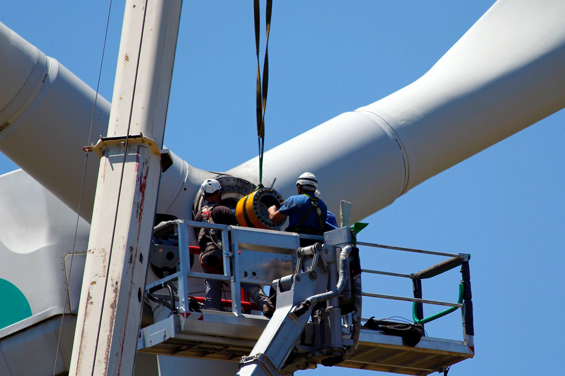 Zwei Techniker reparieren das Getriebe einer Windkraftanlage