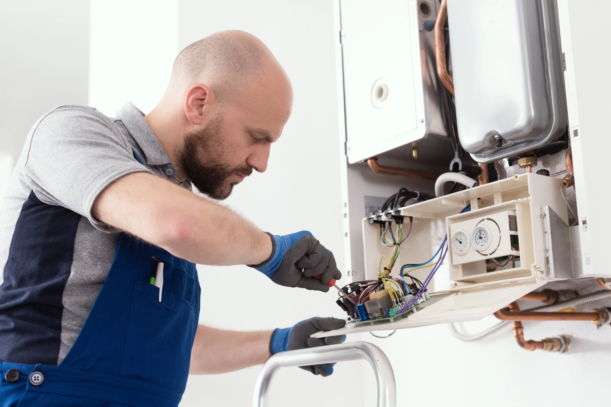 Anlagenmechaniker wartet einen Heizungskessel